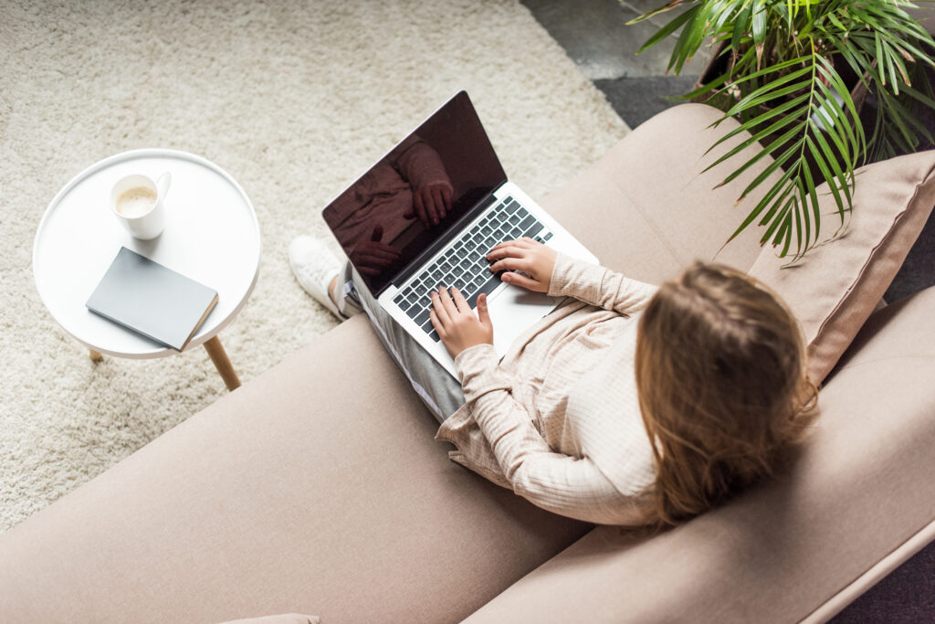 woman sitting on a couch working on her laptop